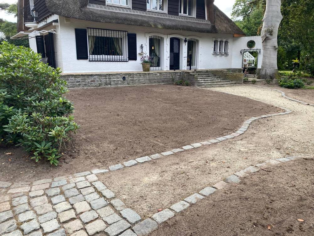 Dezelfde voortuin tijdens de werken, met kale grond klaar voor inzaai.